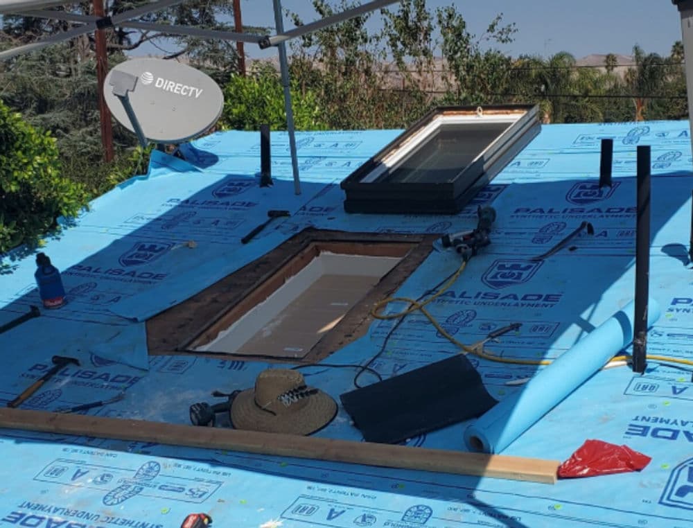 Roofing project with skylight opening, tools, and DirectTV dish installation visible.