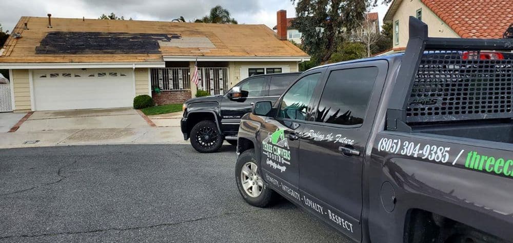 Roof repair truck in front of home with damaged roof, ready for restoration services.